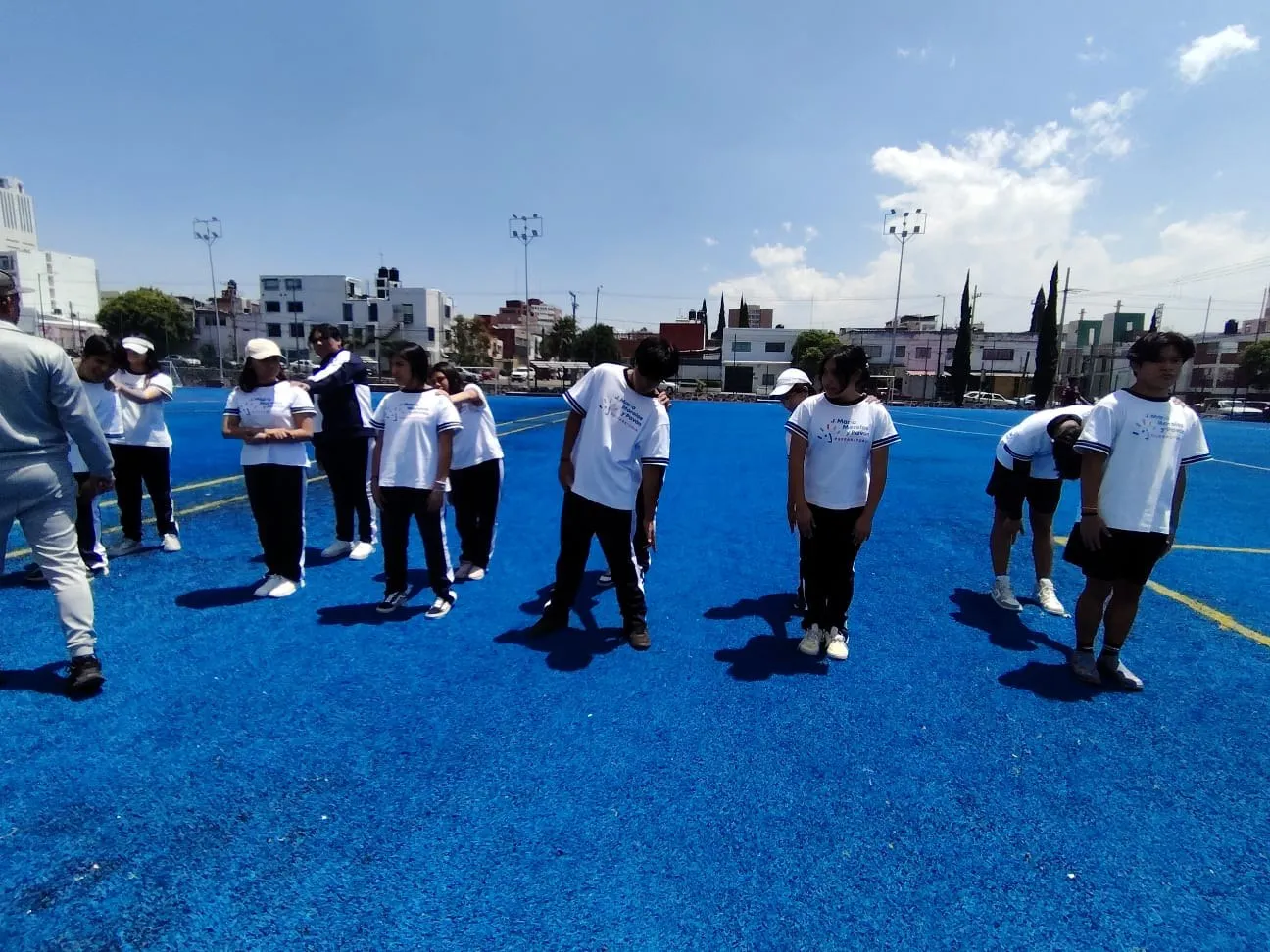 Alumnos de uniforme en la cancha del plantel