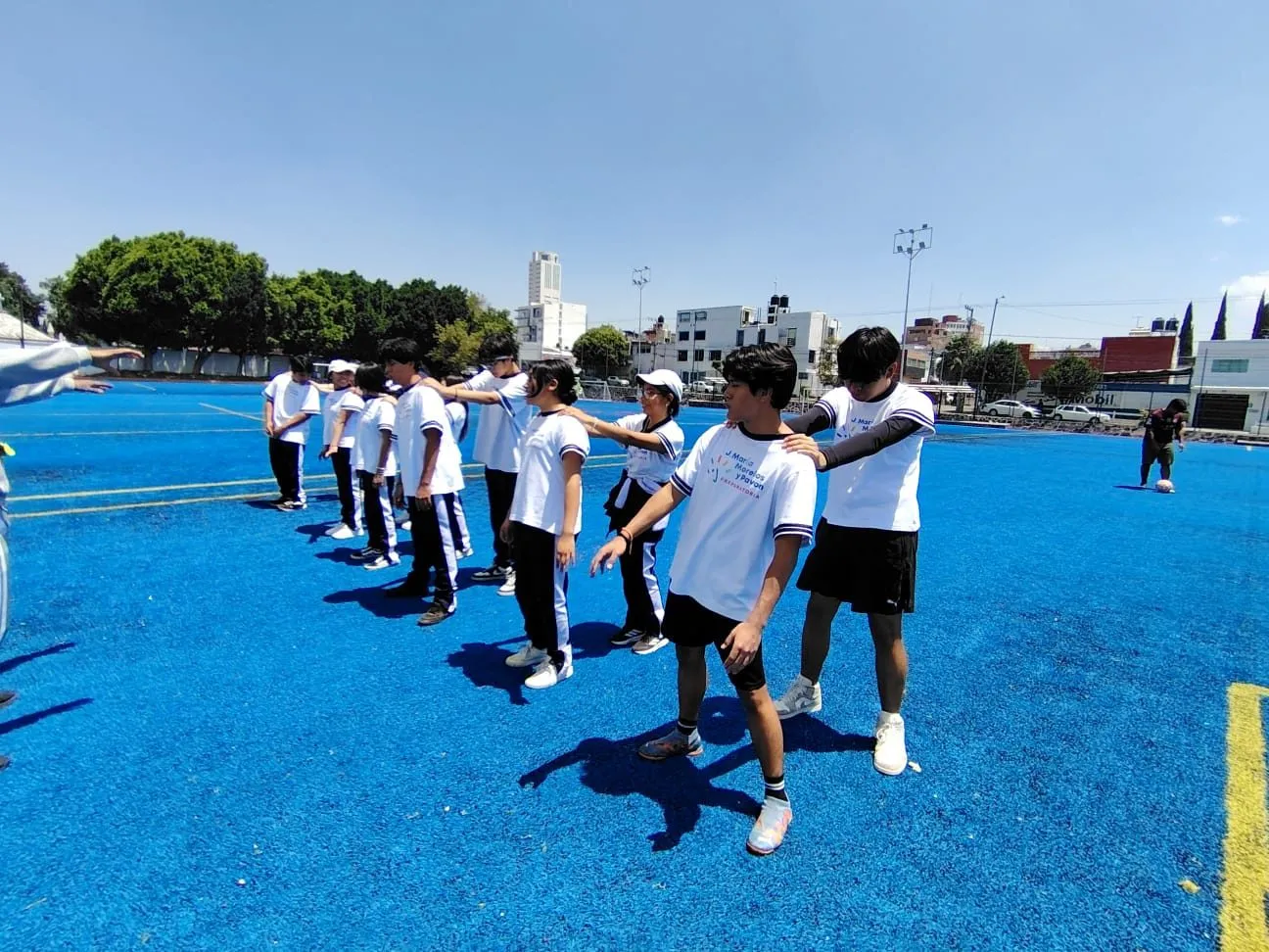 Alumnos en activación deportiva sobre la cancha azul