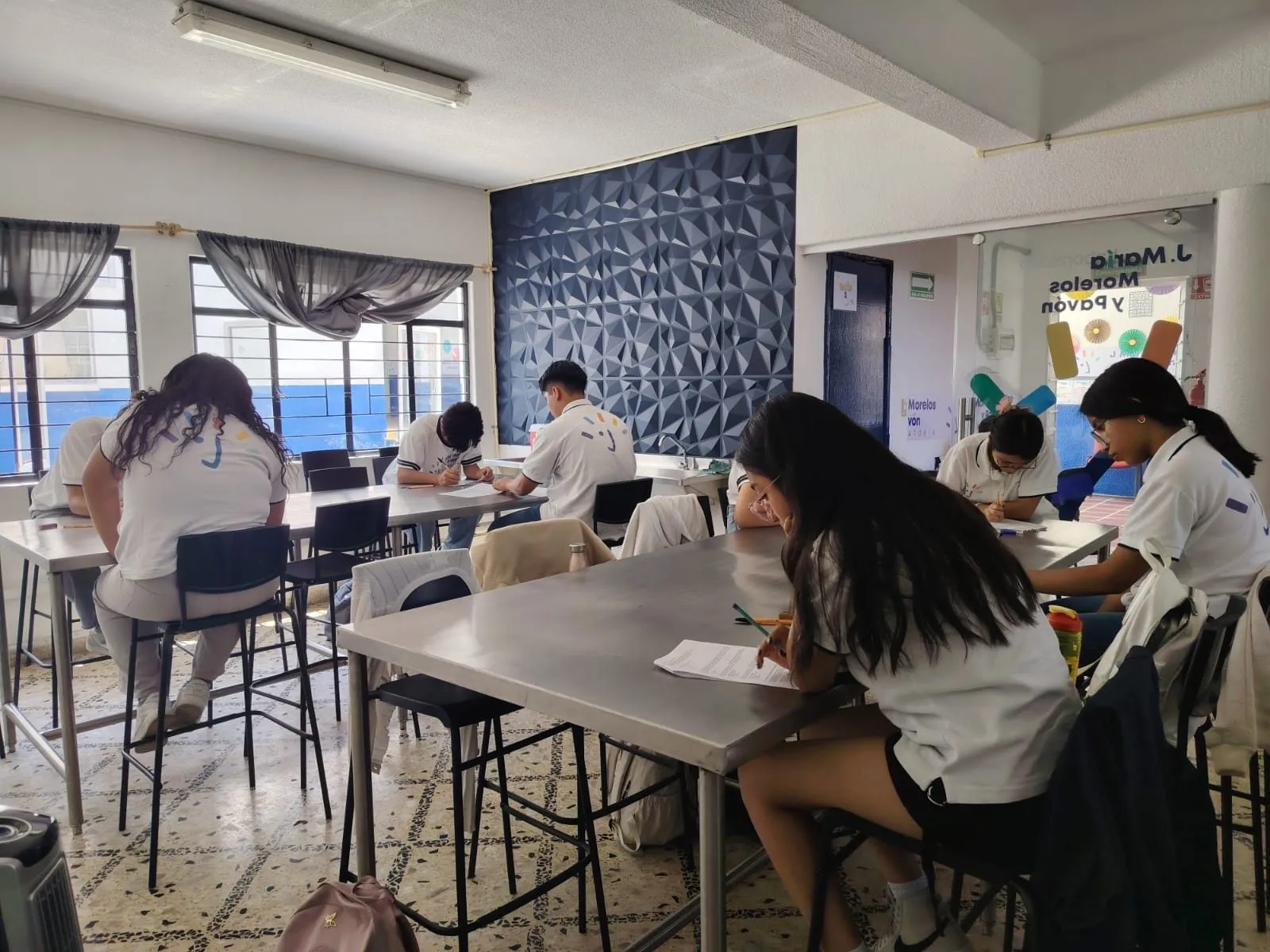 Salón de clases con alumnos trabajando en equipo